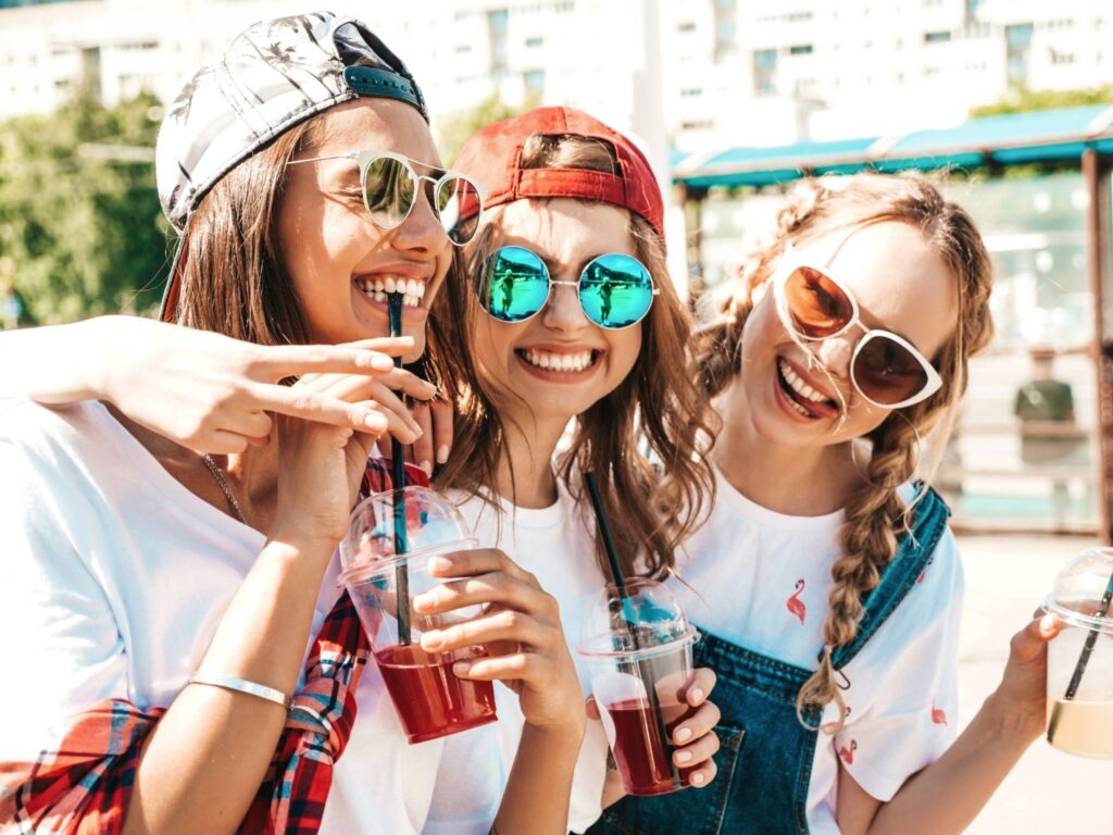 Friends smiling and drinking from plastic cups